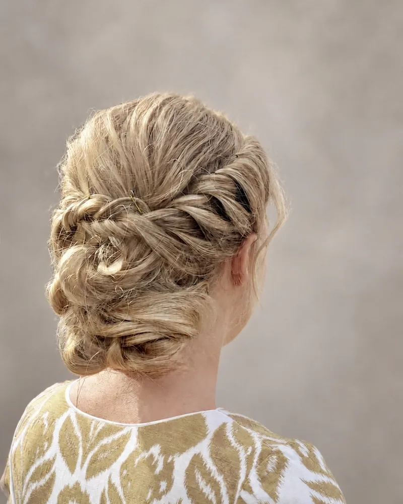 Braided updo with twisted sections for an event, seen from behind